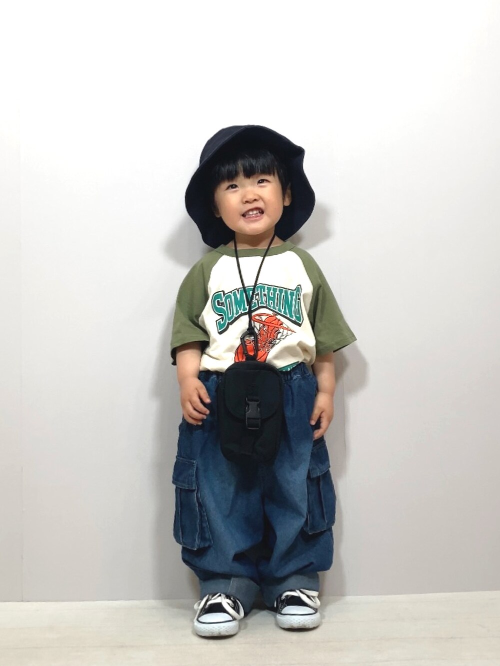 グリーン系のTシャツ/カットソー、ブルー系のデニムパンツ、ブラック系のバッグを着用したキッズの夏コーディネートの3枚目の写真