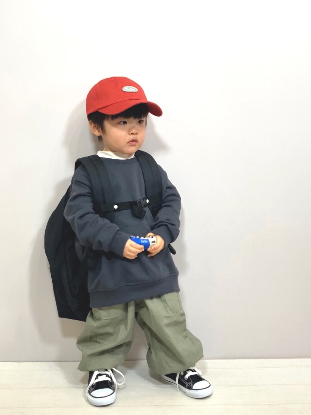 グレー系のスウェット、ホワイト系のTシャツ/カットソー、グリーン系のカーゴパンツを着用したキッズの冬コーディネートの3枚目の写真