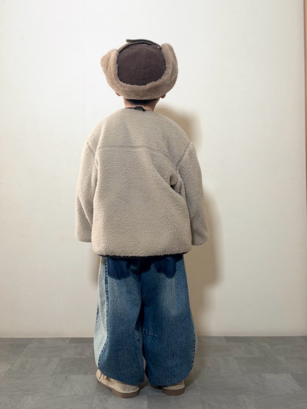 ブラウン系のTシャツ/カットソー、ブラック系のブルゾン、ベージュ系のモカシン/デッキシューズを着用したキッズの冬コーディネートの3枚目の写真