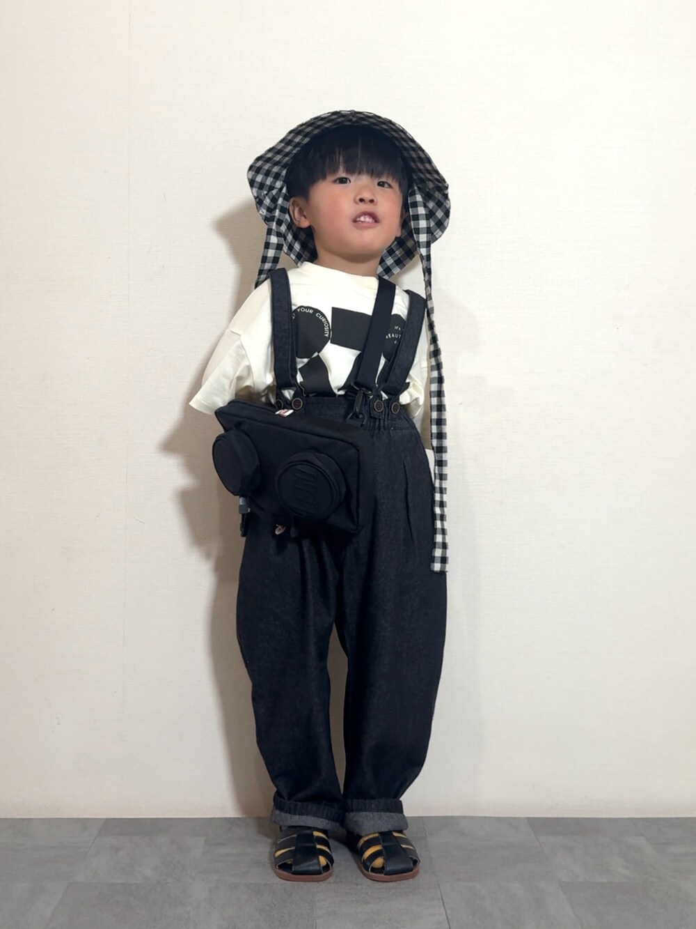ブラック系のTシャツ/カットソー、ブラック系のサロペット/オーバーオール、ブラック系のメッセンジャーバッグを着用したキッズの夏コーディネートの2枚目の写真