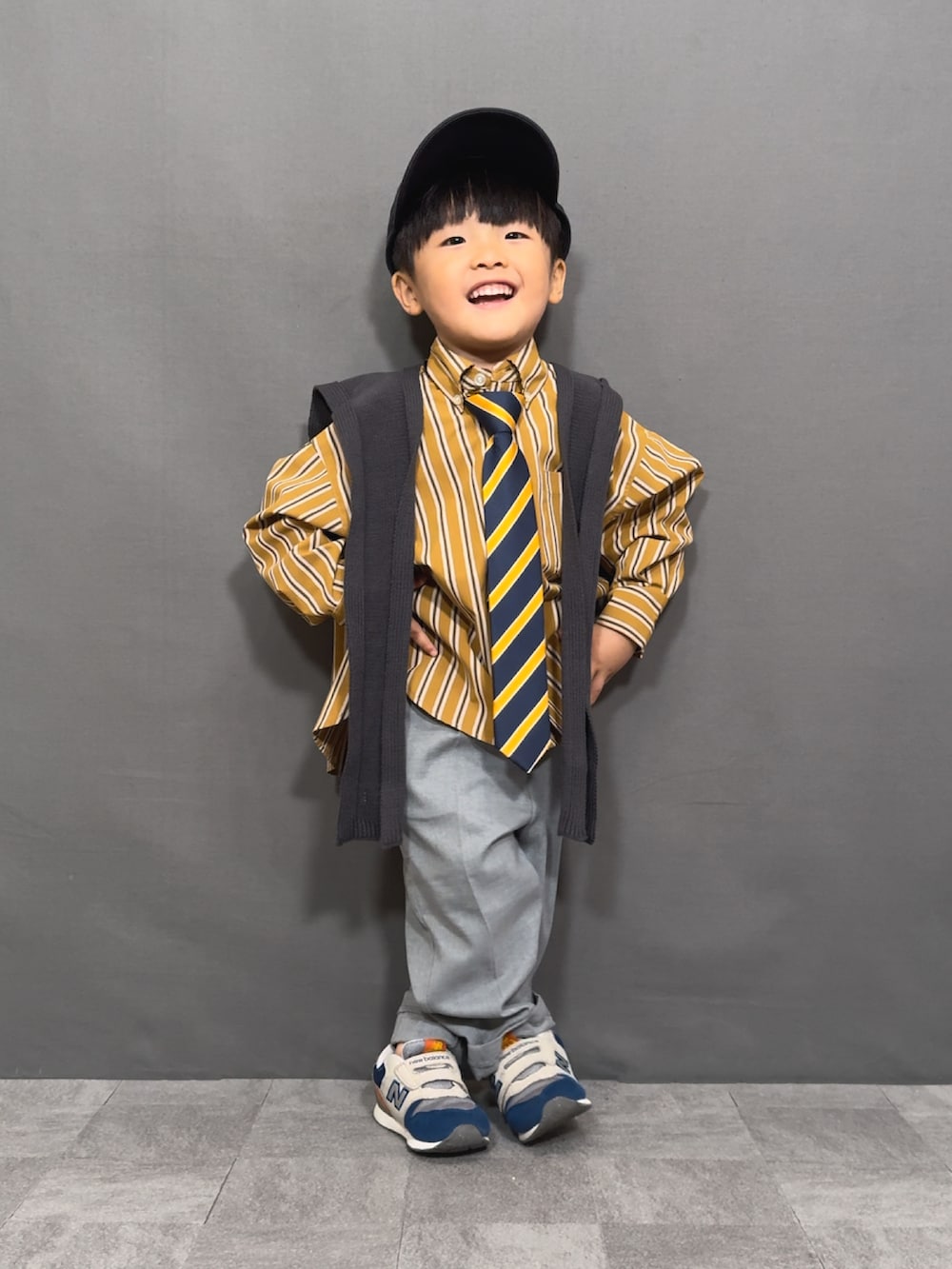 イエロー系のシャツ/ブラウス、イエロー系のネクタイ、グレー系のスラックスを着用したキッズの秋コーディネートの4枚目の写真