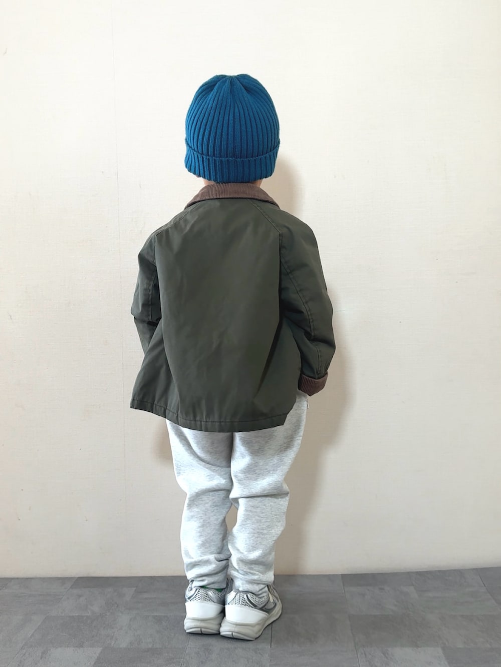 シルバー系のスニーカー、ホワイト系のニット/セーター、グリーン系のジャケット/アウターを着用したキッズの秋コーディネートの4枚目の写真