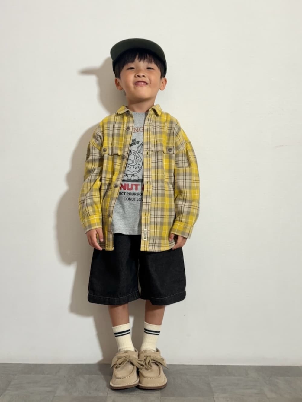 イエロー系のシャツ/ブラウス、グレー系のTシャツ/カットソー、ベージュ系のモカシン/デッキシューズを着用したキッズの秋コーディネートの2枚目の写真
