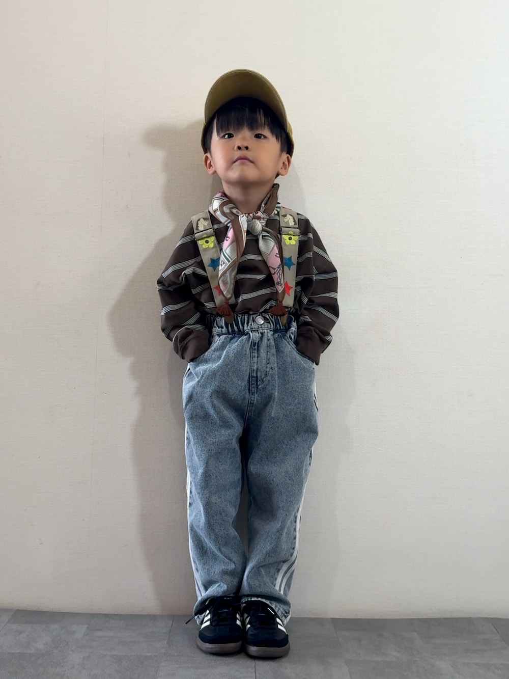 ブルー系のデニムパンツ、ブラック系のスニーカー、ブラウン系のTシャツ/カットソーを着用したキッズの秋コーディネートの2枚目の写真