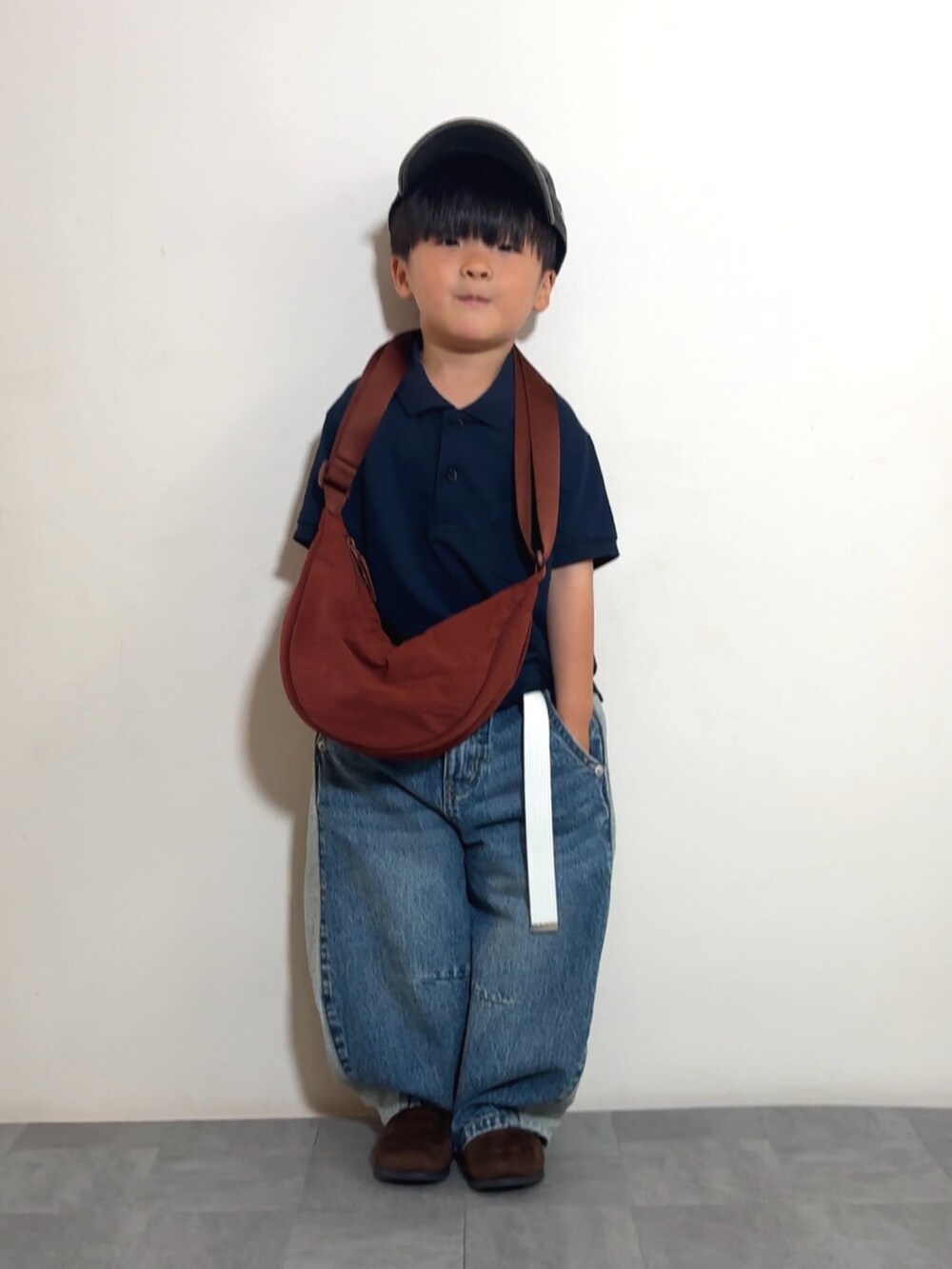 ブルー系のデニムパンツ、ブラウン系のブーツ、ブルー系のポロシャツを着用したキッズの夏コーディネートの2枚目の写真