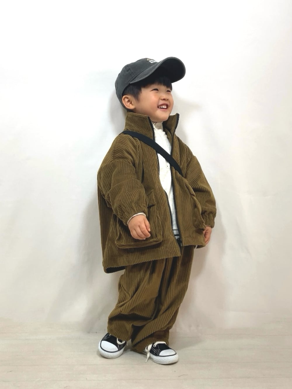 グリーン系のブルゾン、グリーン系のその他パンツ、ブラック系のメッセンジャーバッグを着用したキッズの冬コーディネートの3枚目の写真
