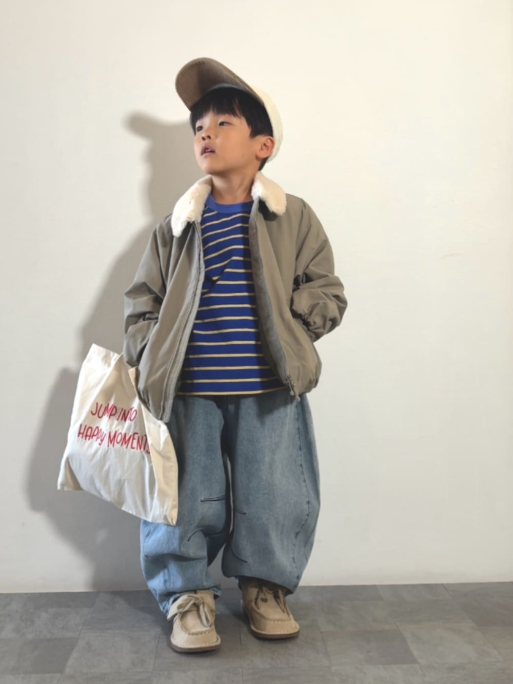 ベージュ系のトートバッグ、ブルー系のTシャツ/カットソー、ベージュ系のモカシン/デッキシューズを着用したキッズの秋コーディネートの2枚目の写真