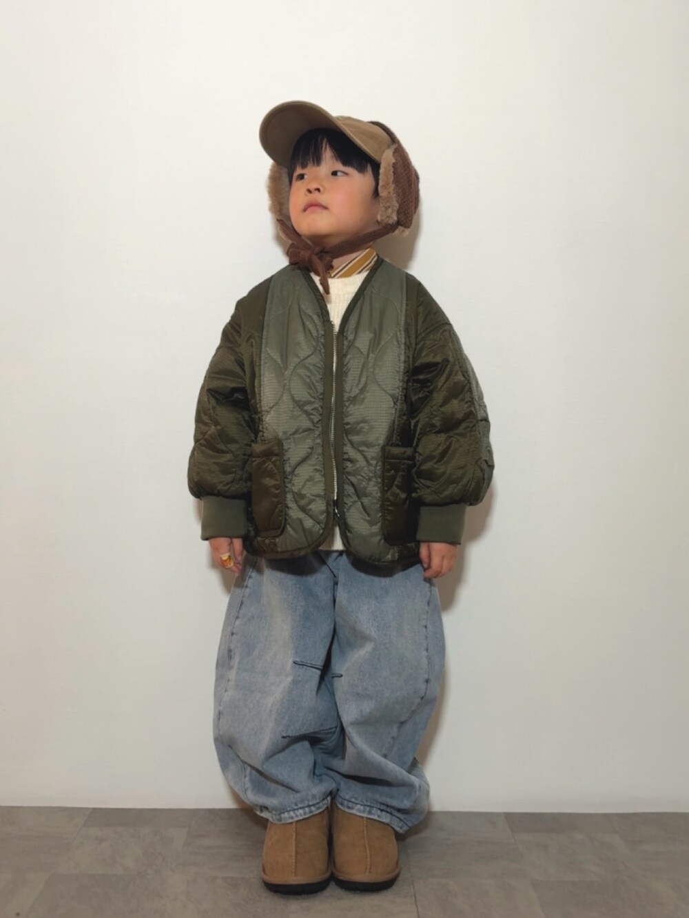 イエロー系のシャツ/ブラウス、イエロー系のブーツ、ブルー系のデニムパンツを着用したキッズの冬コーディネートの2枚目の写真