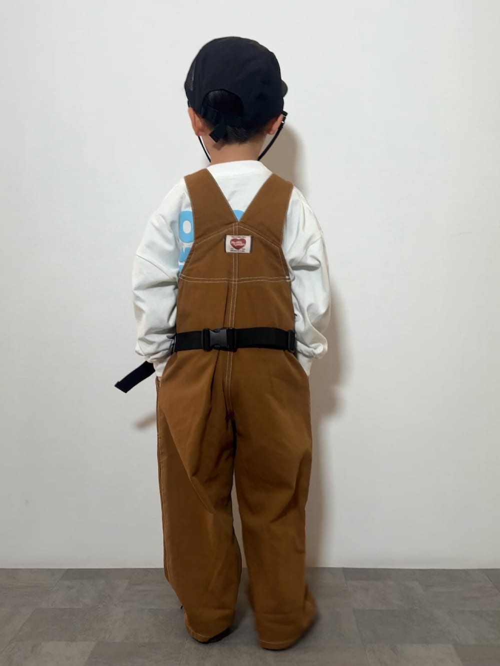 ブラック系のスニーカー、ホワイト系のTシャツ/カットソー、レッド系のボディバッグ/ウエストポーチを着用したキッズの春コーディネートの3枚目の写真