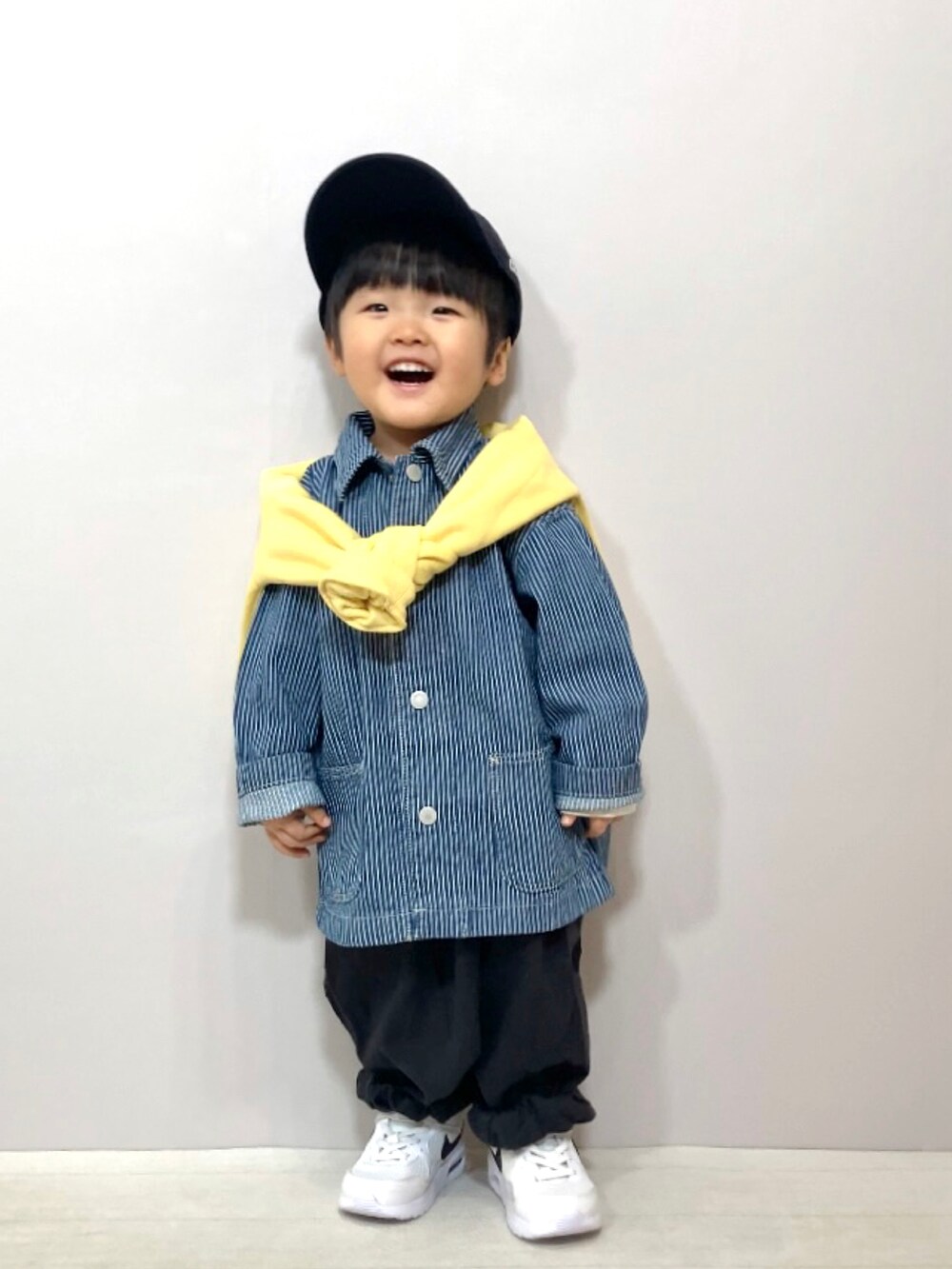 ブルー系のジャケット/アウター、イエロー系のスウェット、グレー系のその他パンツを着用したキッズの冬コーディネートの2枚目の写真