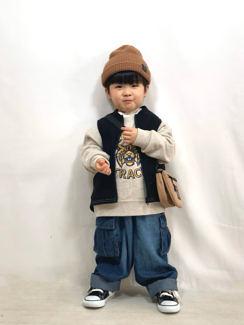 ブラック系のベスト、ホワイト系のスウェット、ホワイト系のTシャツ/カットソーを着用したキッズの冬コーディネートの2枚目の写真