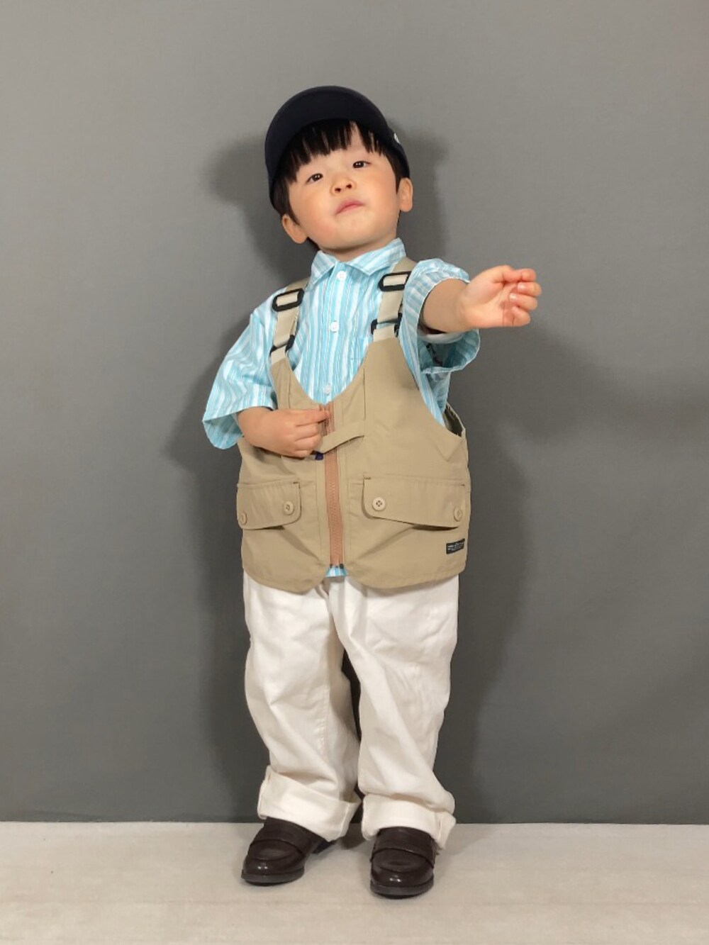ブルー系のシャツ/ブラウス、ベージュ系のベスト、ホワイト系のパンツを着用したキッズの春コーディネートの2枚目の写真