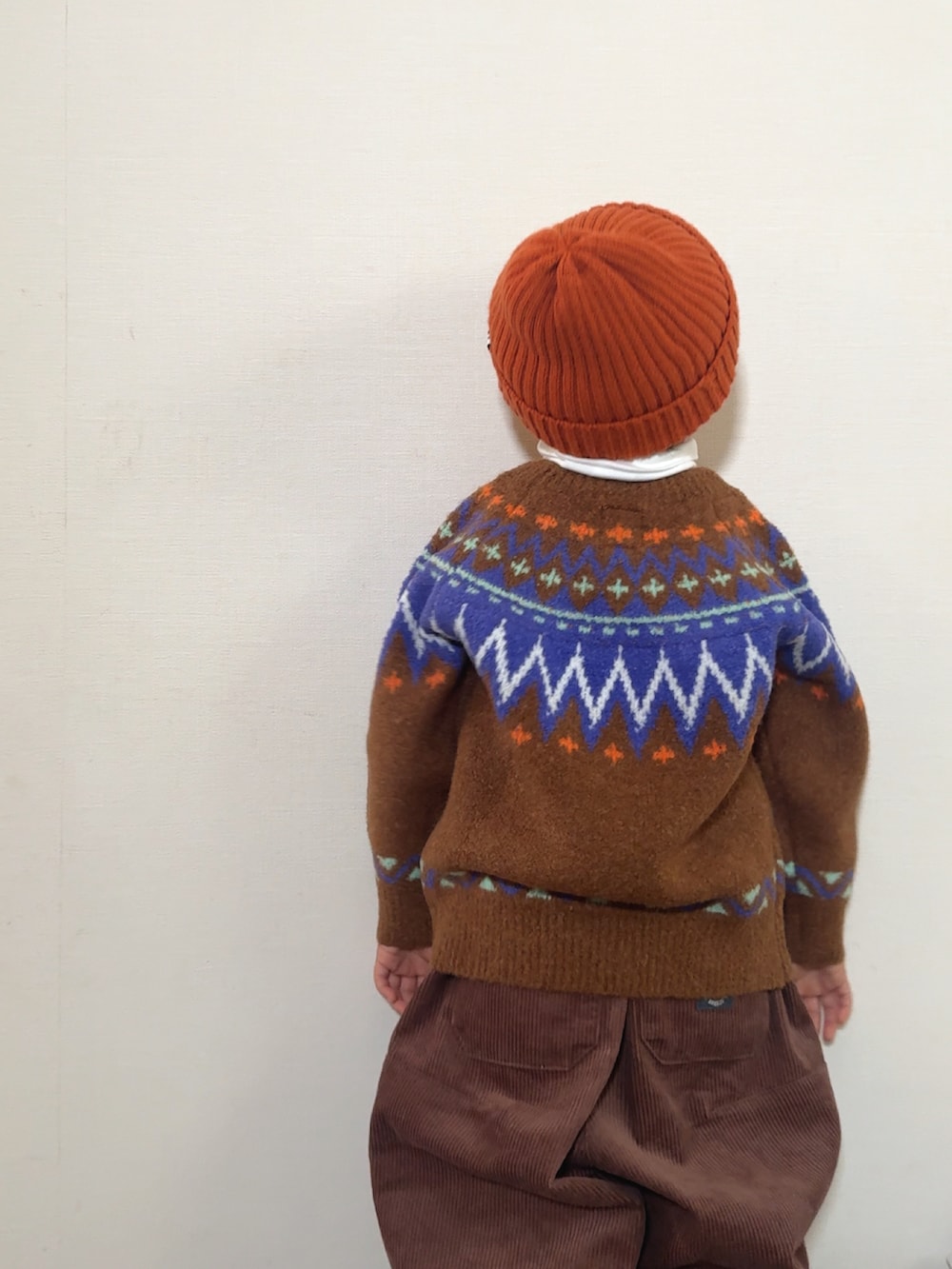 イエロー系のブーツ、ブラウン系のニット/セーター、ブラウン系のその他パンツを着用したキッズの冬コーディネートの4枚目の写真