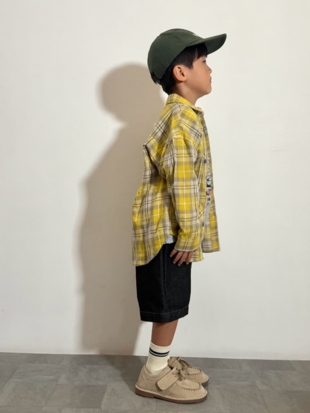 イエロー系のシャツ/ブラウス、グレー系のTシャツ/カットソー、ベージュ系のモカシン/デッキシューズを着用したキッズの秋コーディネートの4枚目の写真