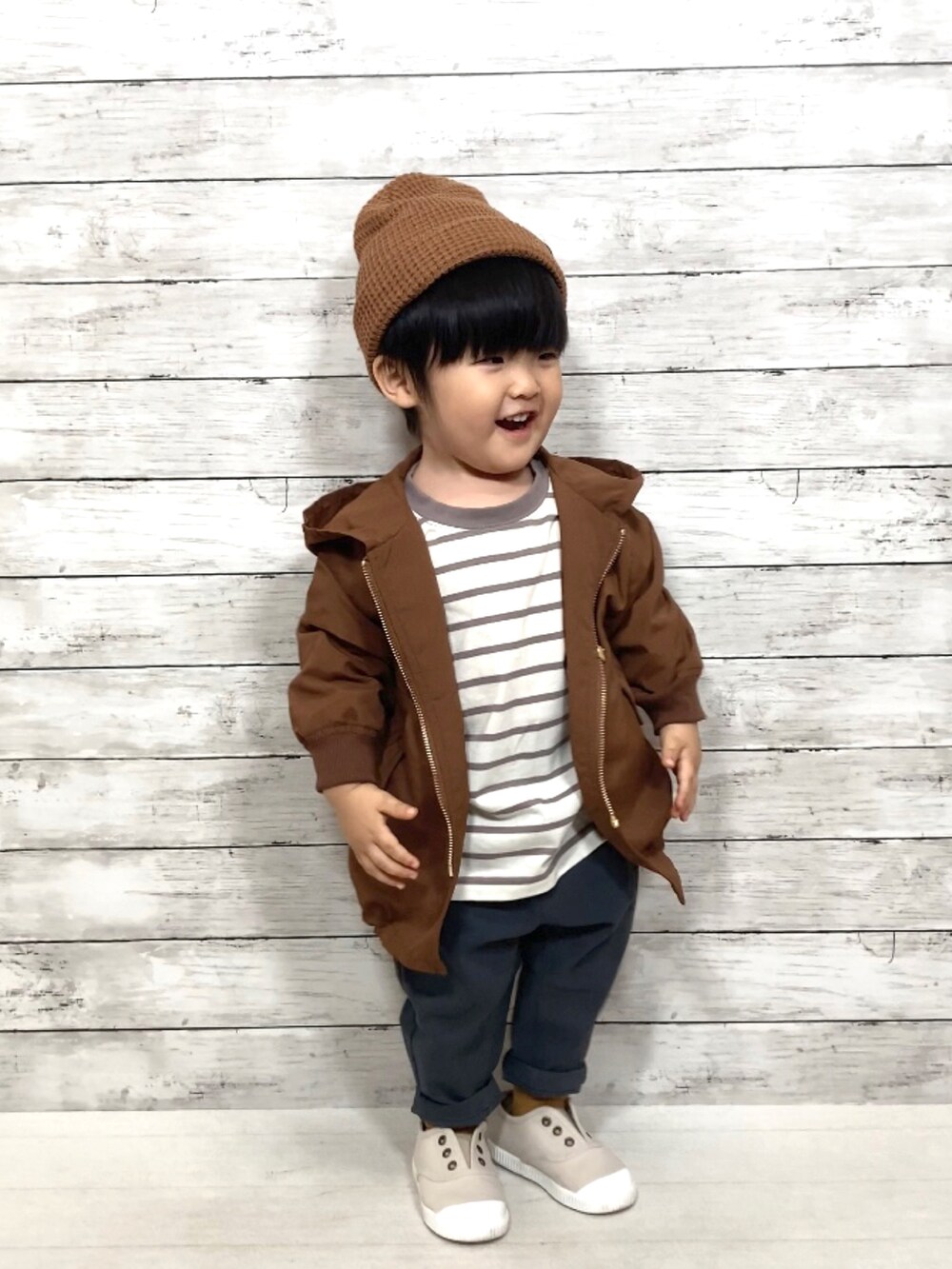 ブラウン系のナイロンジャケット、ベージュ系のTシャツ/カットソー、グレー系のその他パンツを着用したキッズの秋コーディネートの2枚目の写真