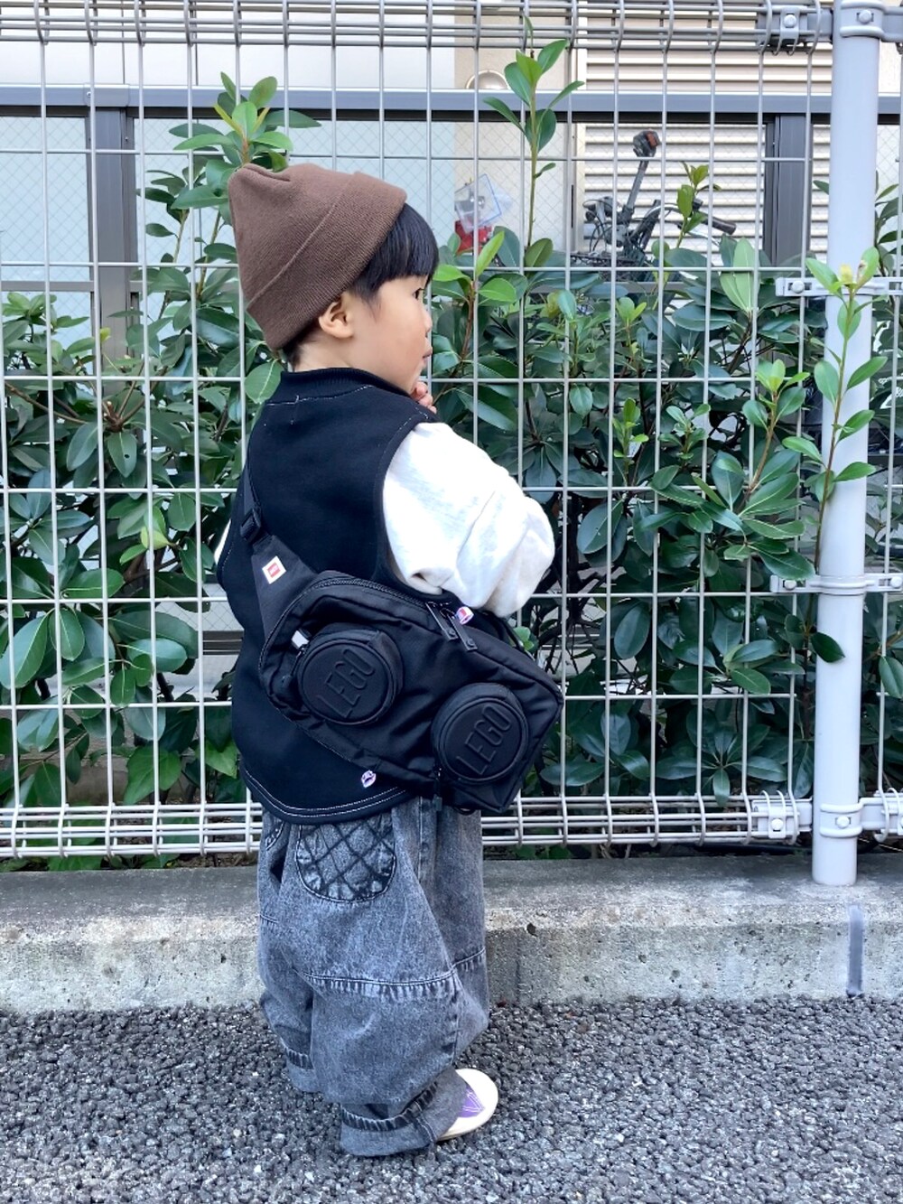 ブラック系のベスト、グレー系のスウェット、ブラック系のデニムパンツを着用したキッズの秋コーディネートの3枚目の写真