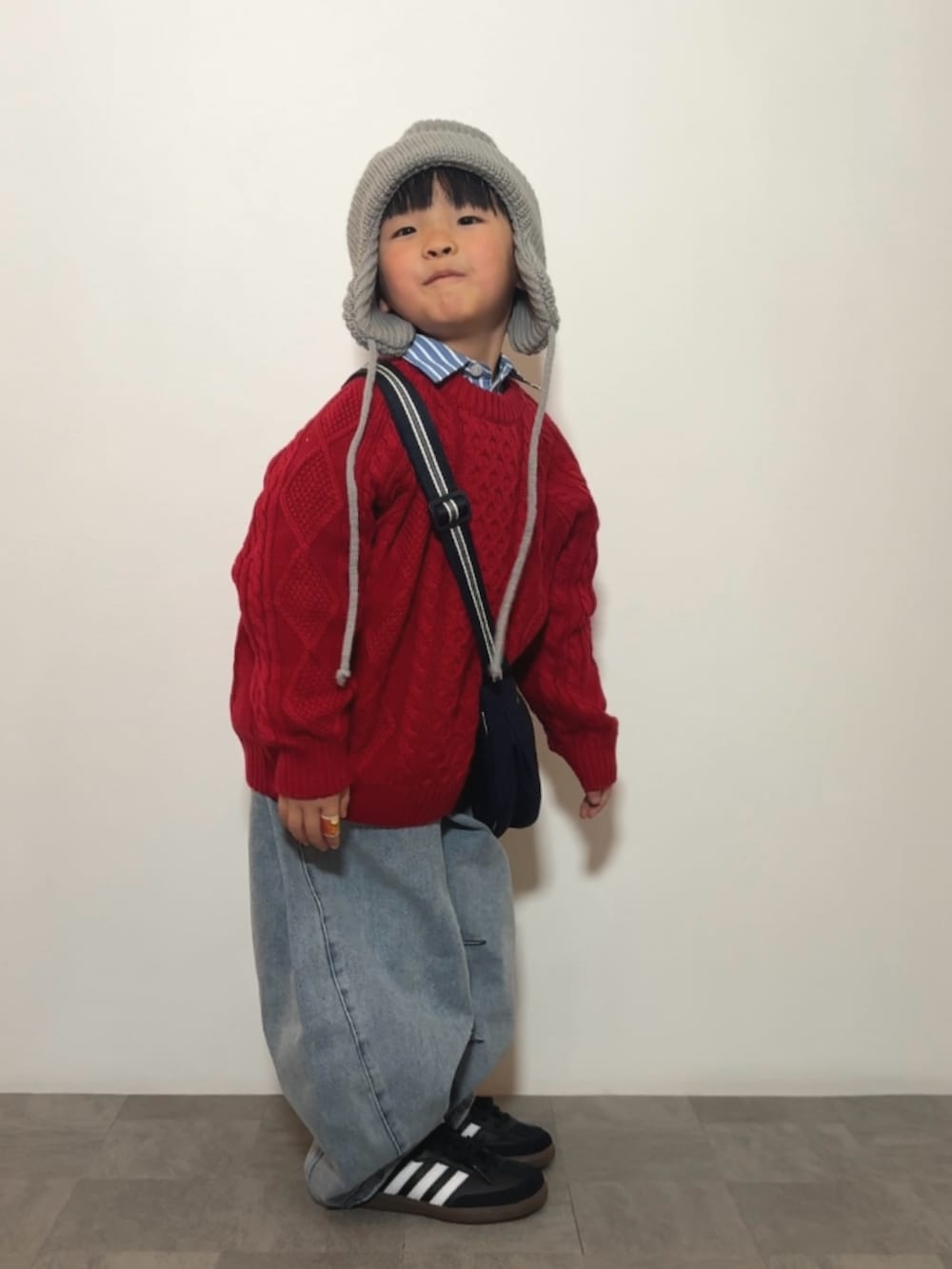 ブルー系のシャツ/ブラウス、レッド系のニット/セーター、ブラック系のスニーカーを着用したキッズの冬コーディネートの2枚目の写真