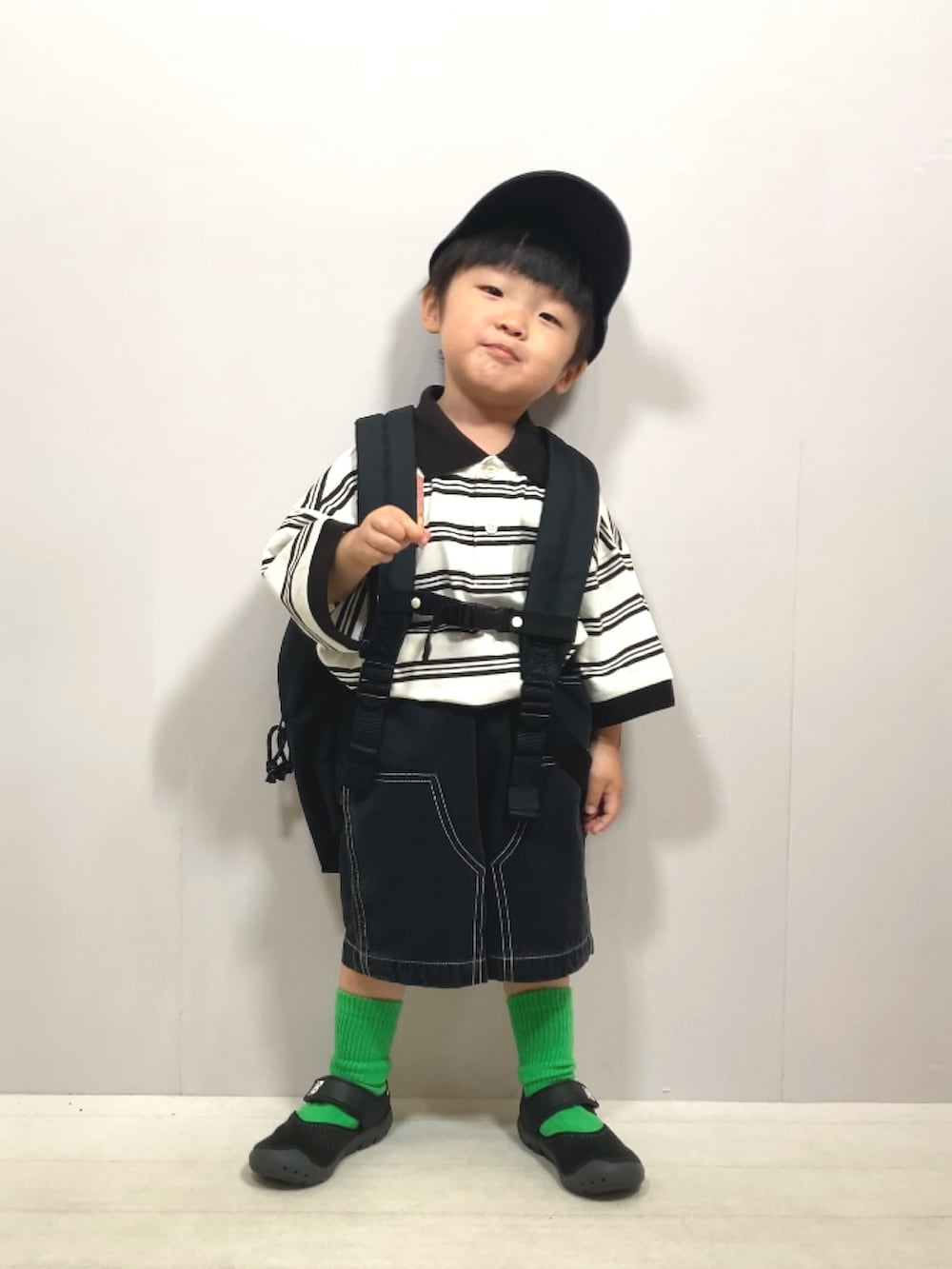 ベージュ系のポロシャツ、ブラック系のその他パンツ、ブラック系のバックパック/リュックを着用したキッズの夏コーディネートの4枚目の写真