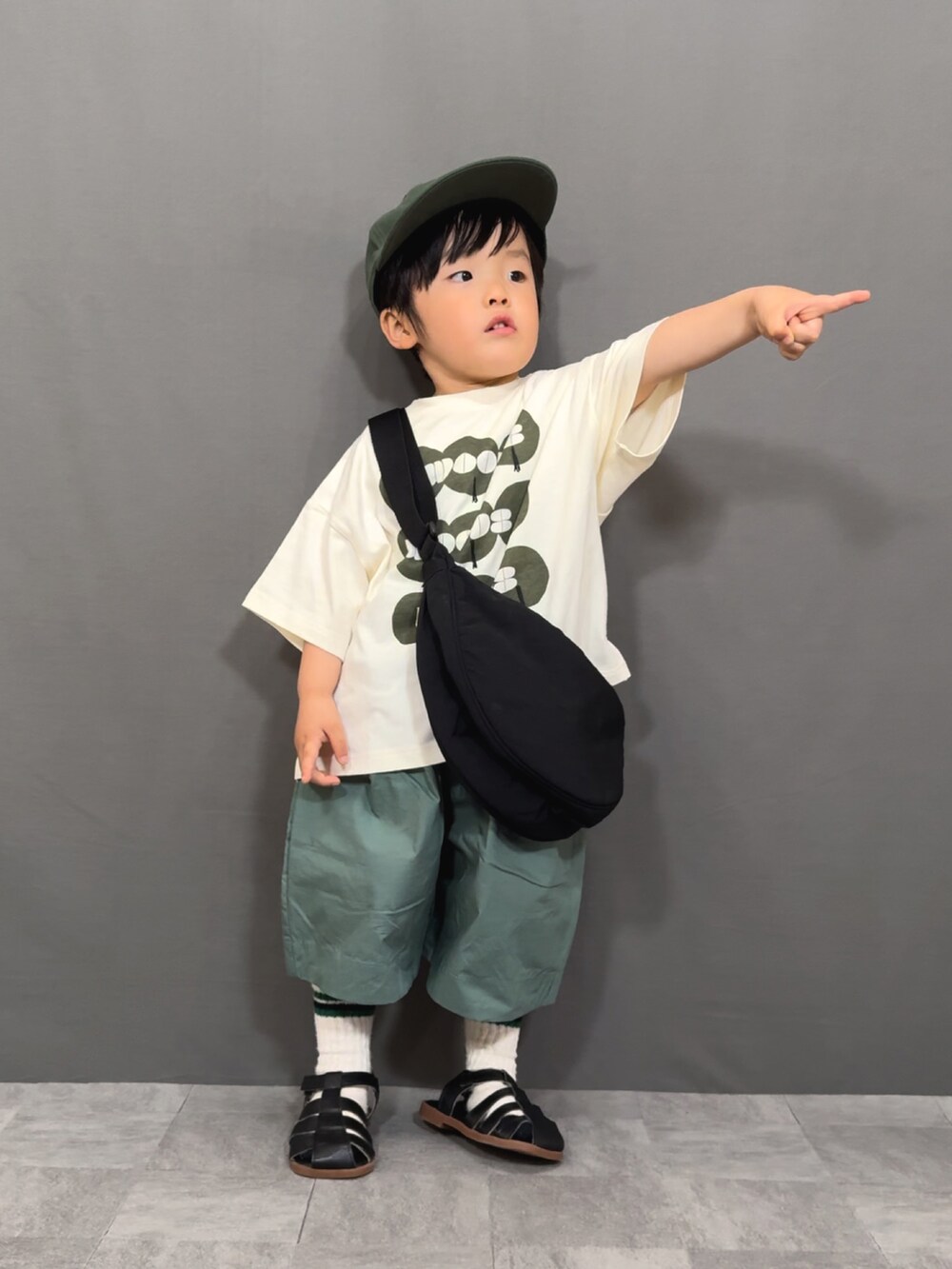 ブラック系のTシャツ/カットソー、グリーン系のその他パンツ、ブラック系のショルダーバッグを着用したキッズの春コーディネートの2枚目の写真