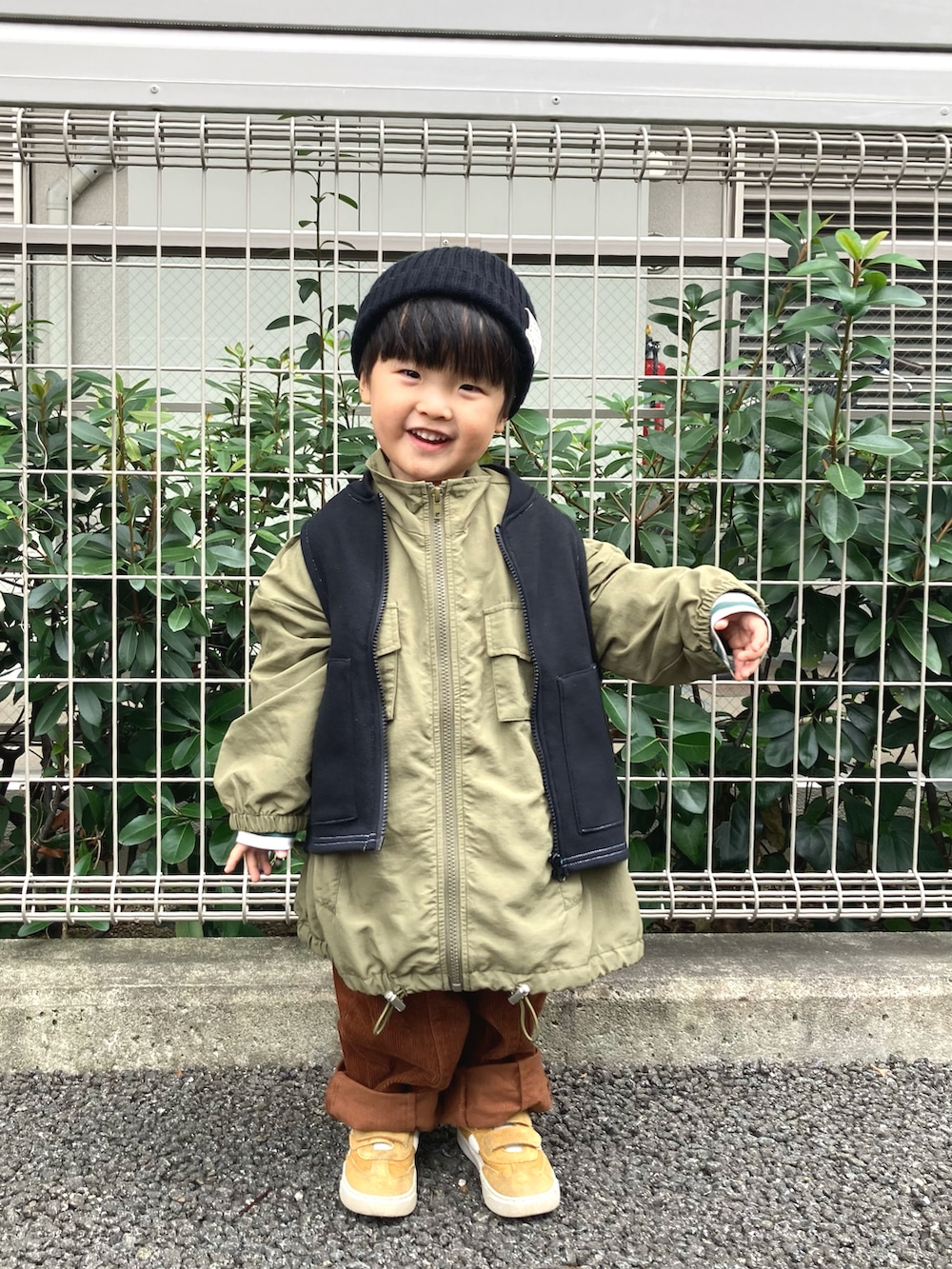 グリーン系のジャケット/アウター、ブラック系のベスト、グリーン系のTシャツ/カットソーを着用したキッズの秋コーディネートの2枚目の写真