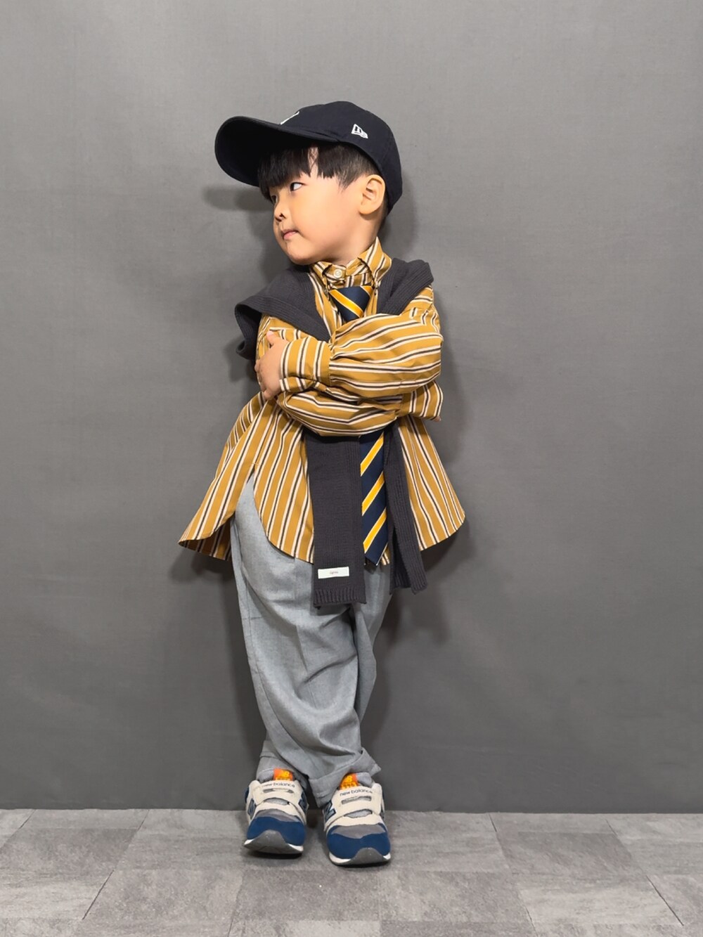 イエロー系のシャツ/ブラウス、イエロー系のネクタイ、グレー系のスラックスを着用したキッズの秋コーディネートの5枚目の写真