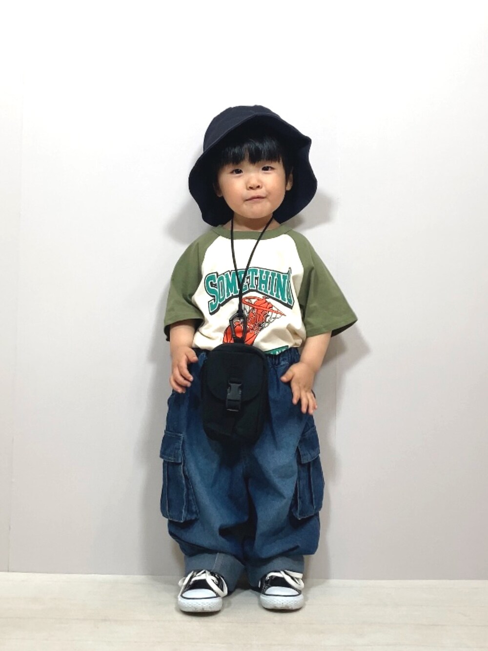 グリーン系のTシャツ/カットソー、ブルー系のデニムパンツ、ブラック系のバッグを着用したキッズの夏コーディネートの2枚目の写真