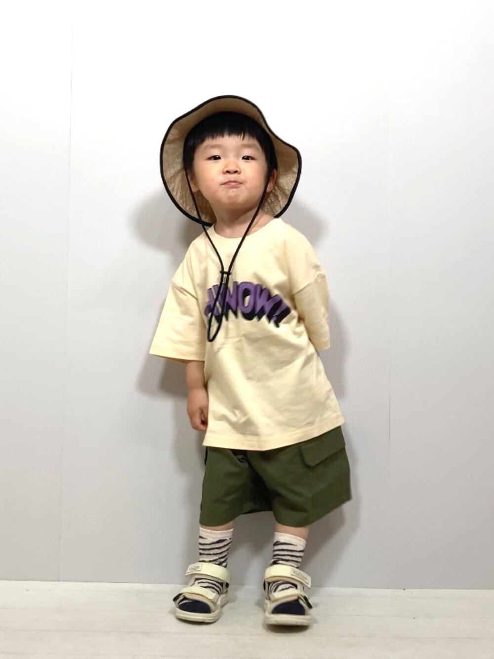 ベージュ系のTシャツ/カットソー、グリーン系のカーゴパンツ、ホワイト系のサンダルを着用したキッズの夏コーディネートの4枚目の写真