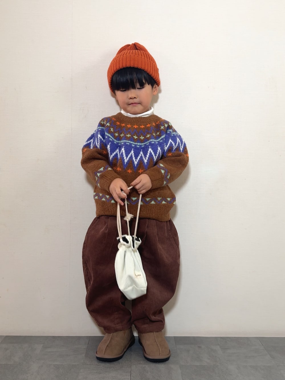 イエロー系のブーツ、ブラウン系のニット/セーター、ブラウン系のその他パンツを着用したキッズの冬コーディネートの2枚目の写真