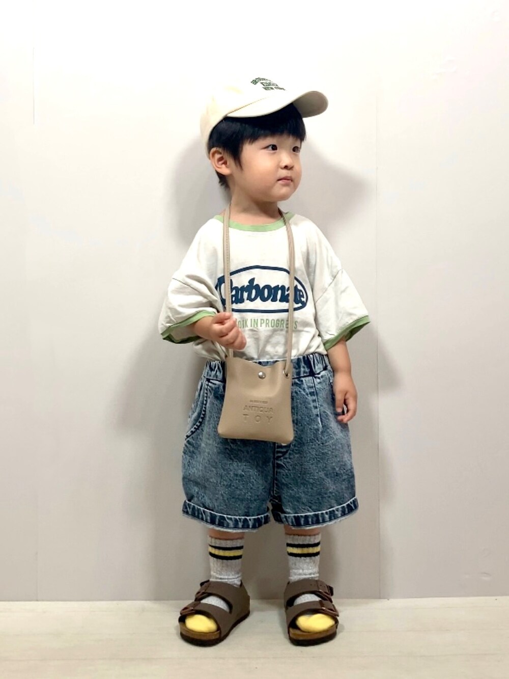 グレー系のTシャツ/カットソー、ブルー系のデニムパンツ、ベージュ系のショルダーバッグを着用したキッズの夏コーディネートの4枚目の写真