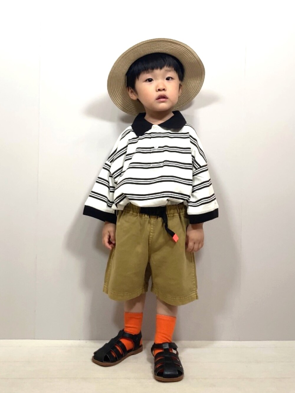 ベージュ系のポロシャツ、イエロー系のその他パンツ、ブラック系のサンダルを着用したキッズの夏コーディネートの2枚目の写真