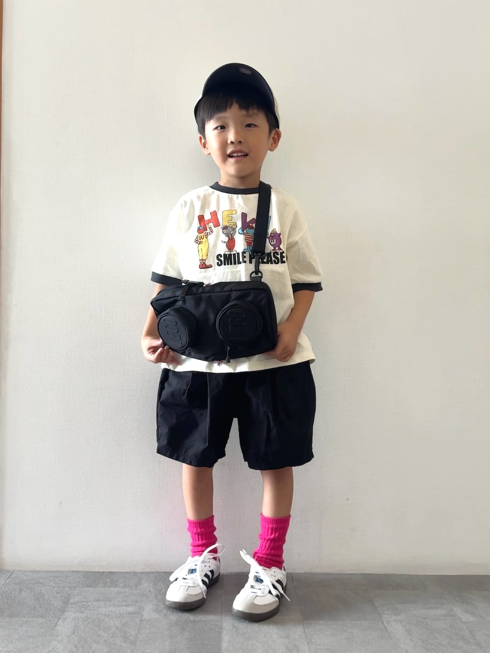 ホワイト系のTシャツ/カットソー、ブラック系のその他パンツ、ブラック系のメッセンジャーバッグを着用したキッズの夏コーディネートの2枚目の写真