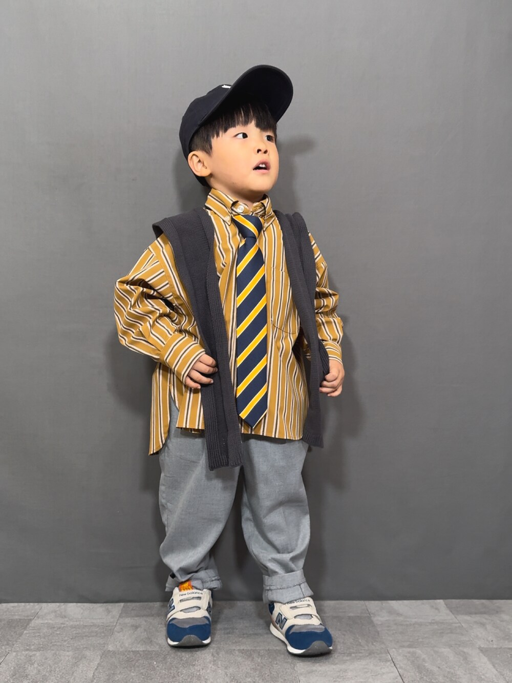 イエロー系のシャツ/ブラウス、イエロー系のネクタイ、グレー系のスラックスを着用したキッズの秋コーディネートの2枚目の写真