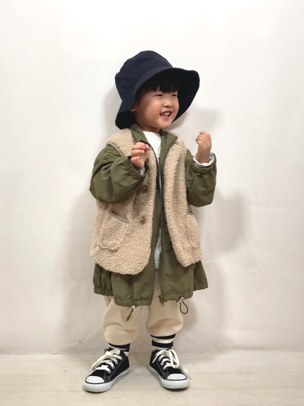 ベージュ系のベスト、グリーン系のジャケット/アウター、グレー系のTシャツ/カットソーを着用したキッズの秋コーディネートの4枚目の写真