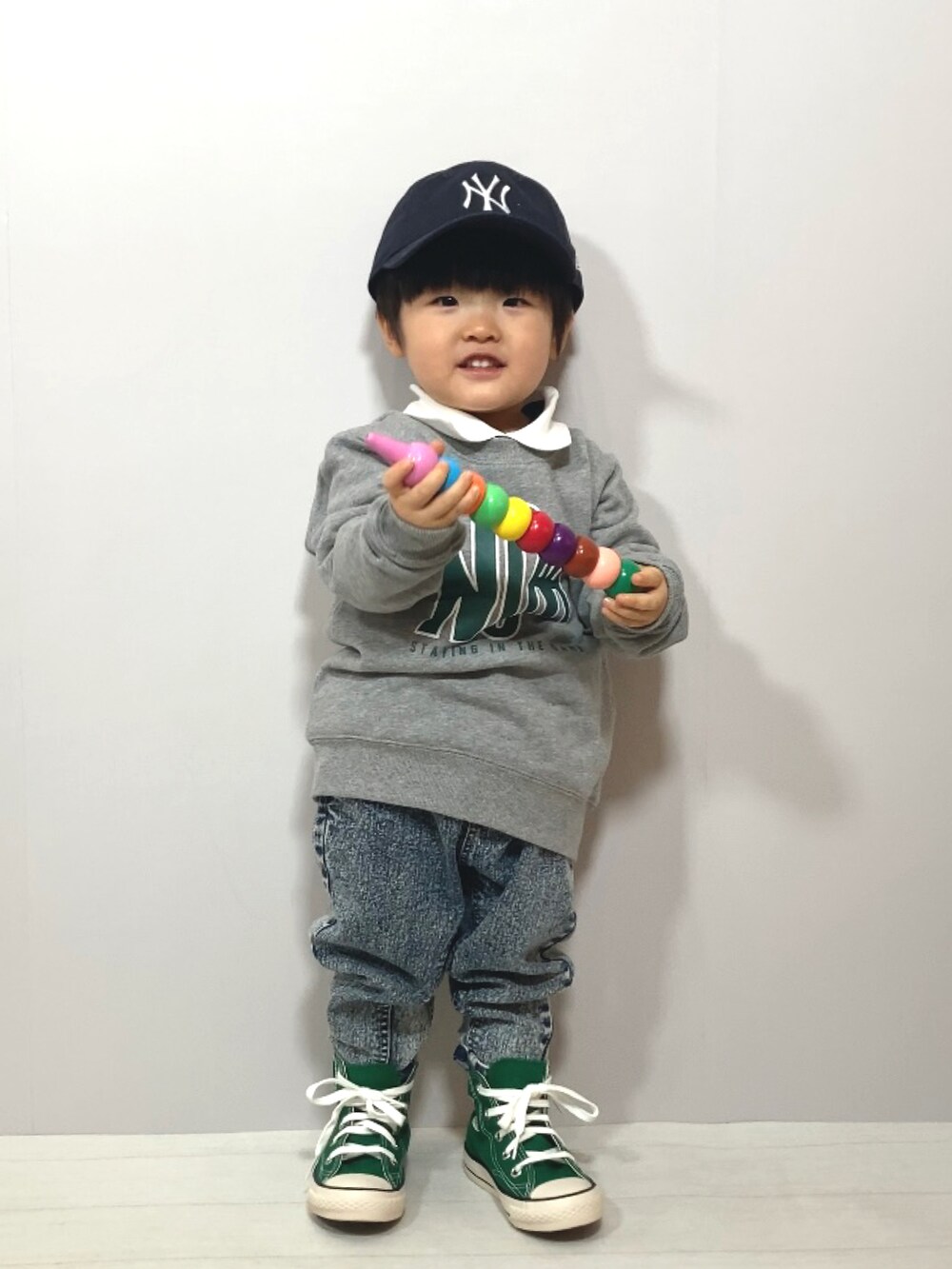 グレー系のスウェット、ブルー系のトップス、その他のデニムパンツを着用したキッズの冬コーディネートの2枚目の写真