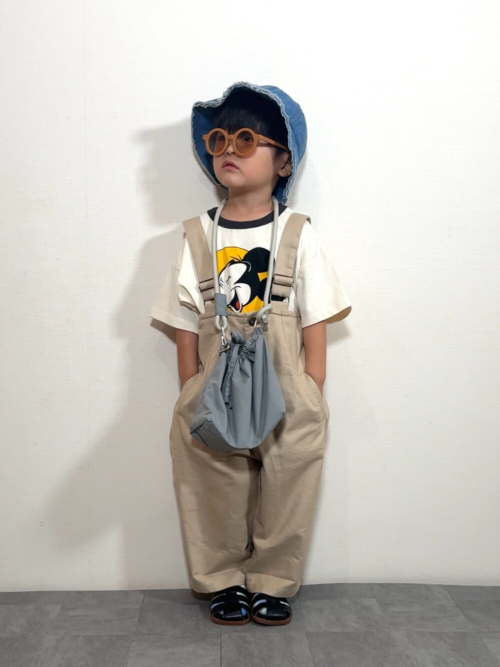 ホワイト系のTシャツ/カットソー、ベージュ系のサロペット/オーバーオール、グレー系のショルダーバッグを着用したキッズの夏コーディネートの2枚目の写真