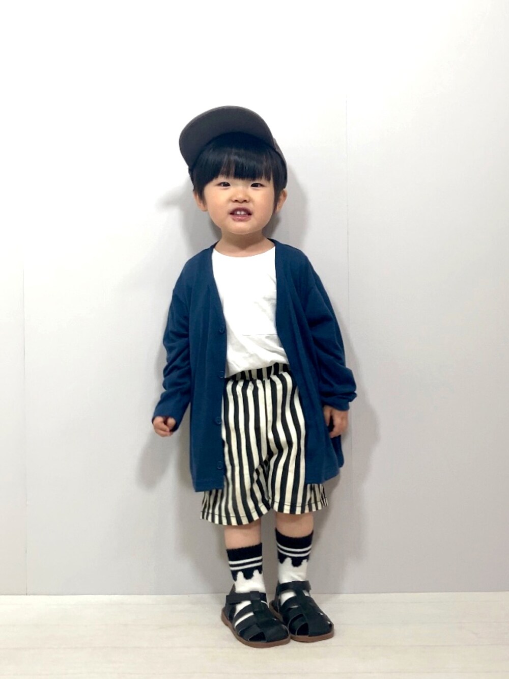 ブルー系のカーディガン/ボレロ、ホワイト系のTシャツ/カットソー、ブラック系のその他パンツを着用したキッズの春コーディネートの2枚目の写真