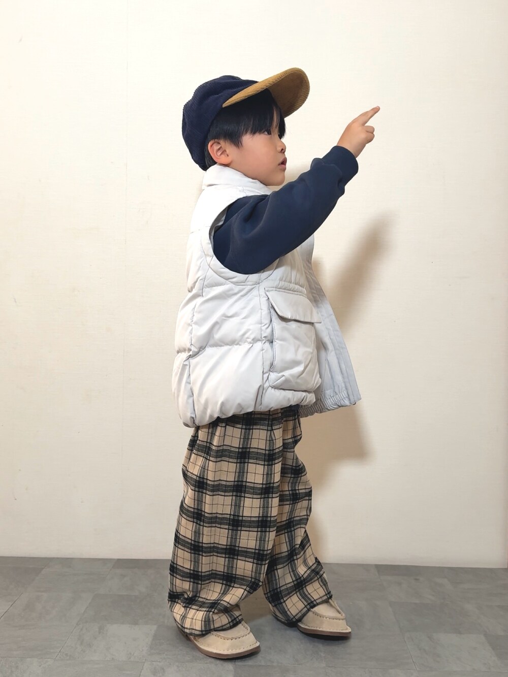 ベージュ系のモカシン/デッキシューズ、ブルー系のスウェット、ホワイト系のジャケット/アウターを着用したキッズの冬コーディネートの3枚目の写真