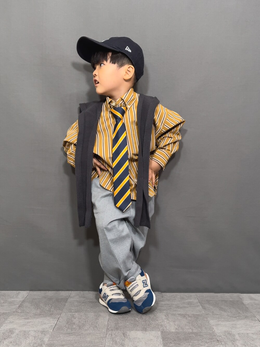 イエロー系のシャツ/ブラウス、イエロー系のネクタイ、グレー系のスラックスを着用したキッズの秋コーディネートの3枚目の写真