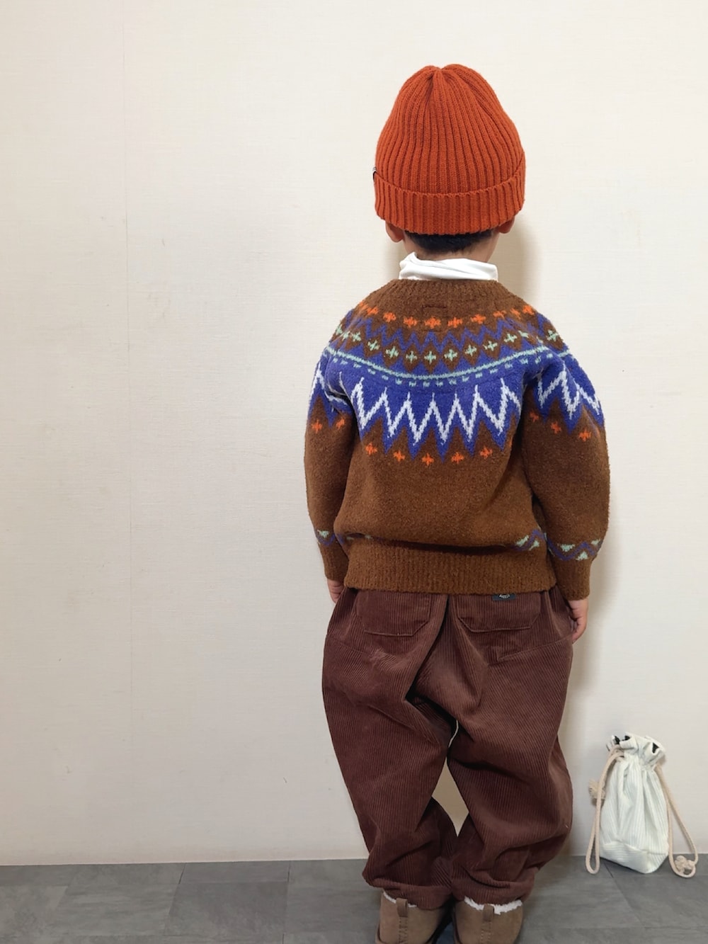 イエロー系のブーツ、ブラウン系のニット/セーター、ブラウン系のその他パンツを着用したキッズの冬コーディネートの3枚目の写真