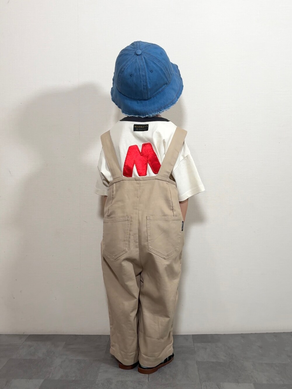 ホワイト系のTシャツ/カットソー、ベージュ系のサロペット/オーバーオール、グレー系のショルダーバッグを着用したキッズの夏コーディネートの3枚目の写真