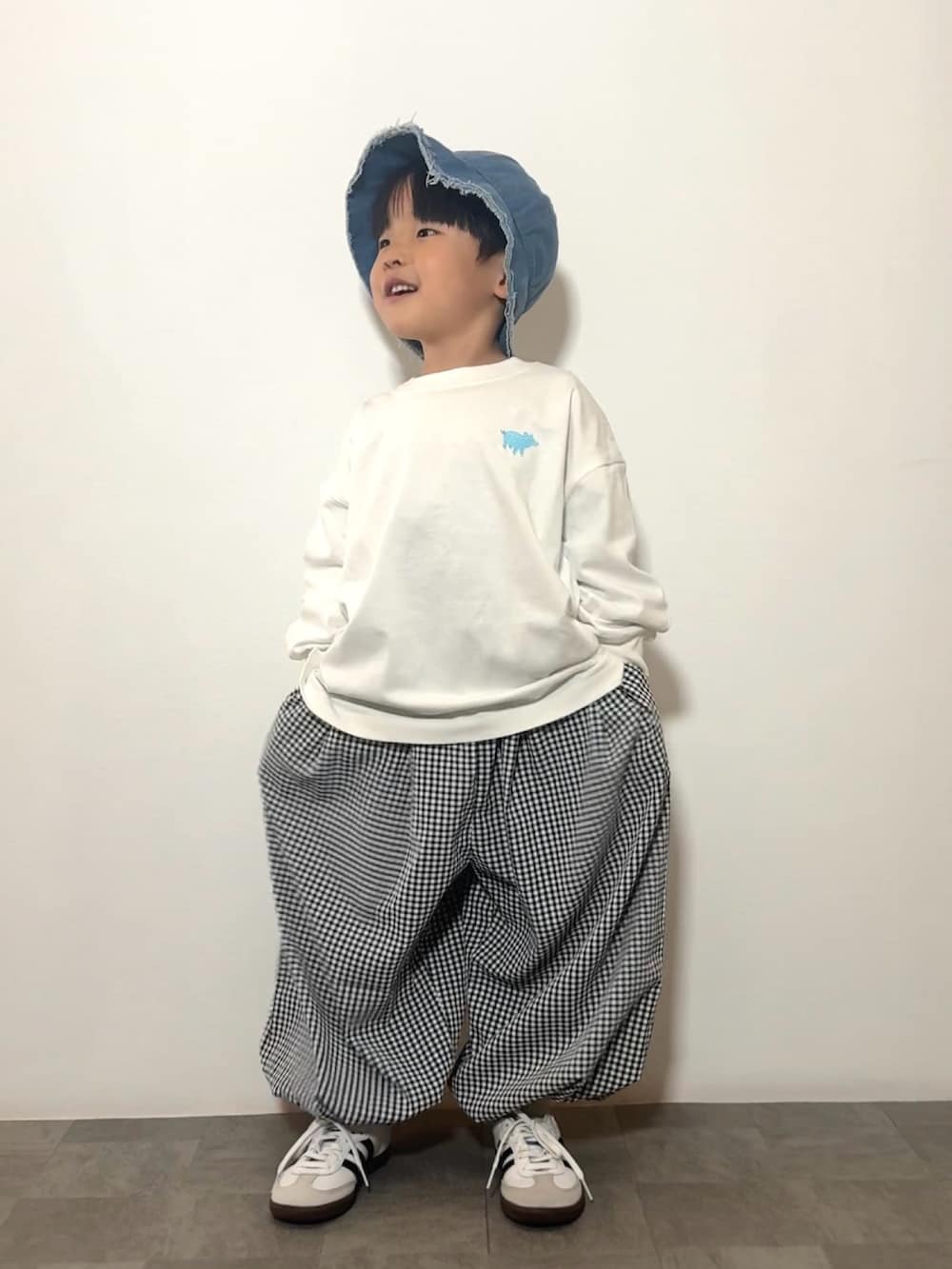 ホワイト系のTシャツ/カットソー、ブラック系のその他パンツ、ホワイト系のスニーカーを着用したキッズの春コーディネートの2枚目の写真