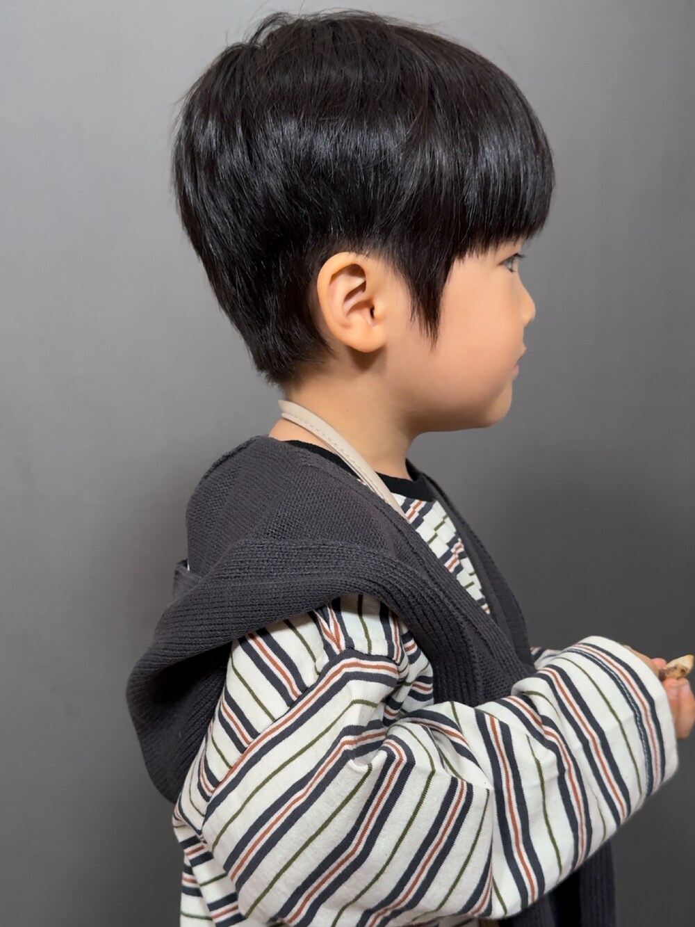 ホワイト系のトップス、ブルー系のデニムパンツ、ベージュ系のショルダーバッグを着用したキッズの秋コーディネートの5枚目の写真