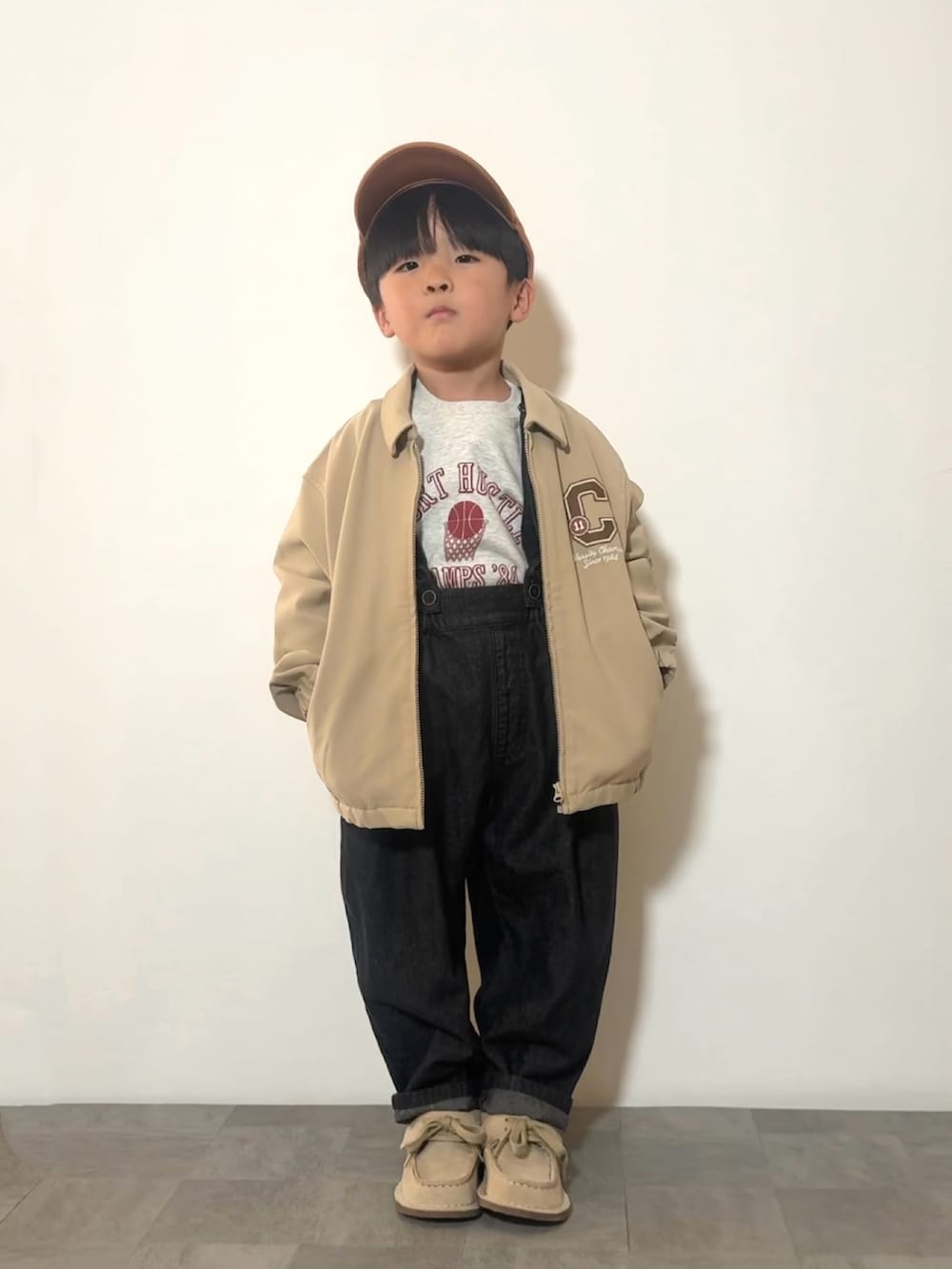 ブラック系のサロペット/オーバーオール、ベージュ系のモカシン/デッキシューズ、グレー系のスウェットを着用したキッズの冬コーディネートの2枚目の写真