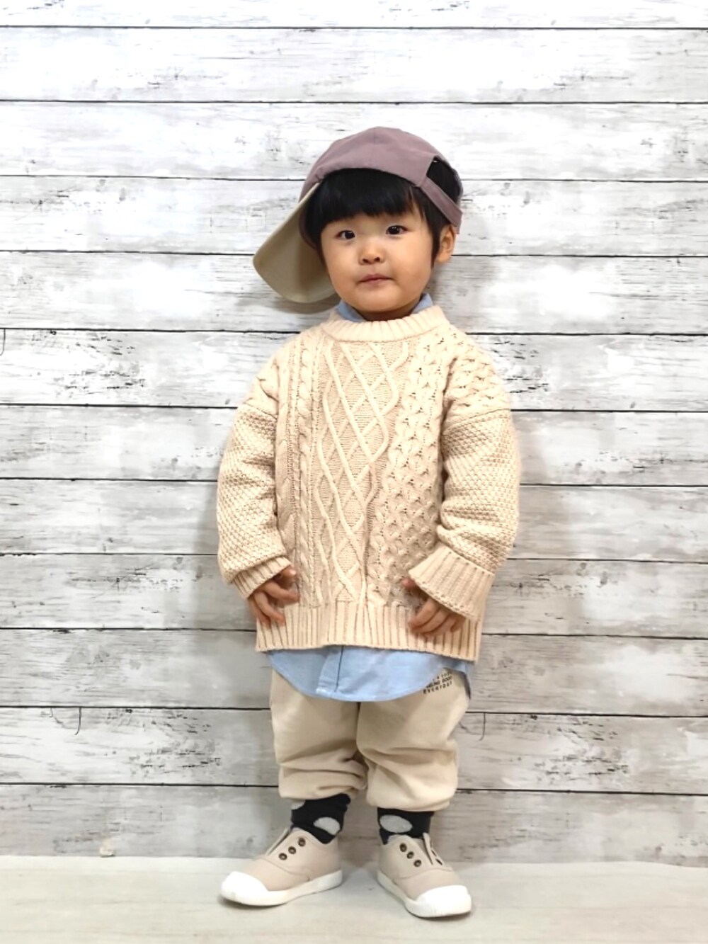 ホワイト系のニット/セーター、ホワイト系のスウェットパンツ、ベージュ系のシューズを着用したキッズの冬コーディネートの2枚目の写真