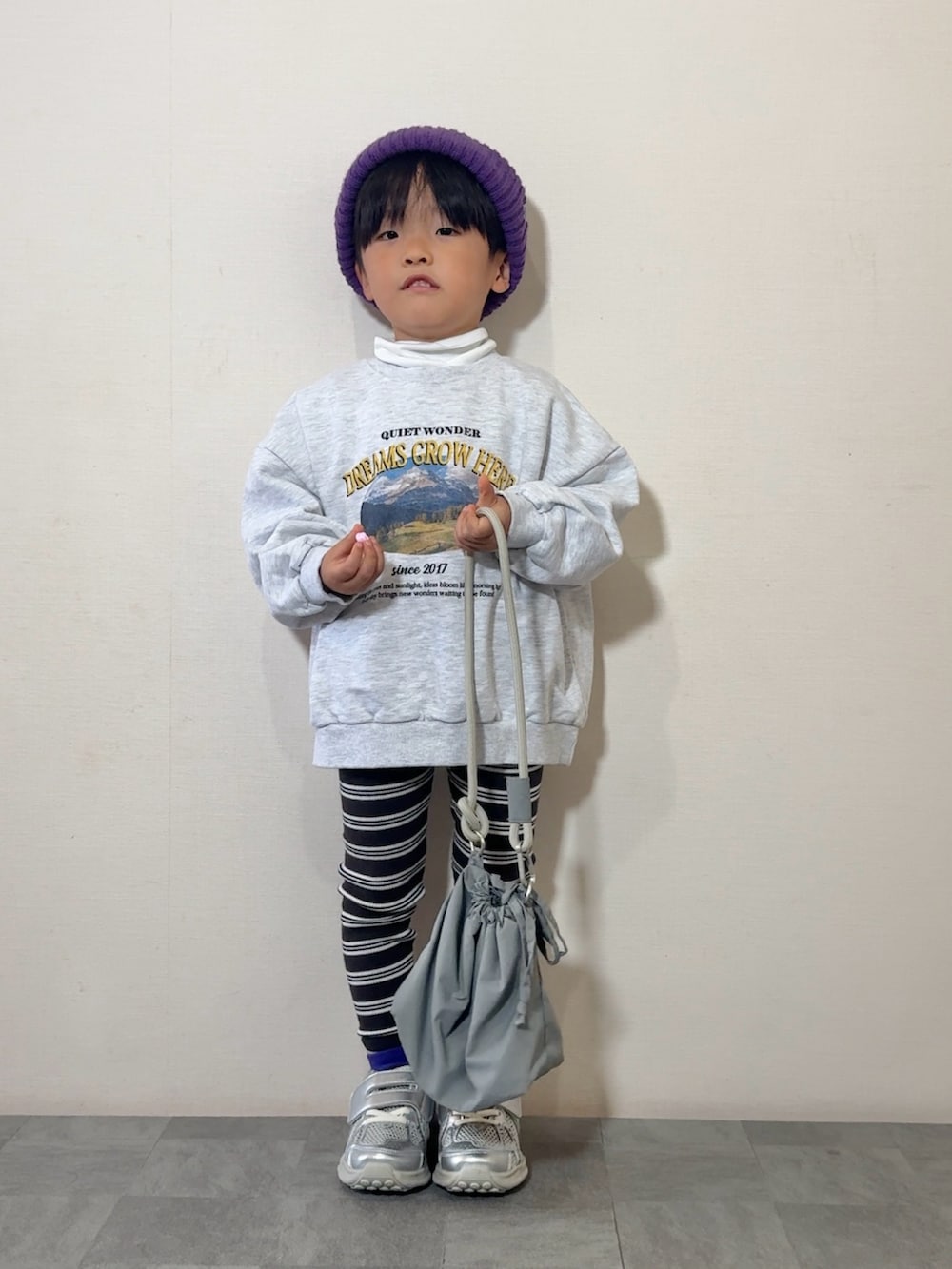 シルバー系のスニーカー、グレー系のショルダーバッグ、ホワイト系のスウェットを着用したキッズの秋コーディネートの2枚目の写真