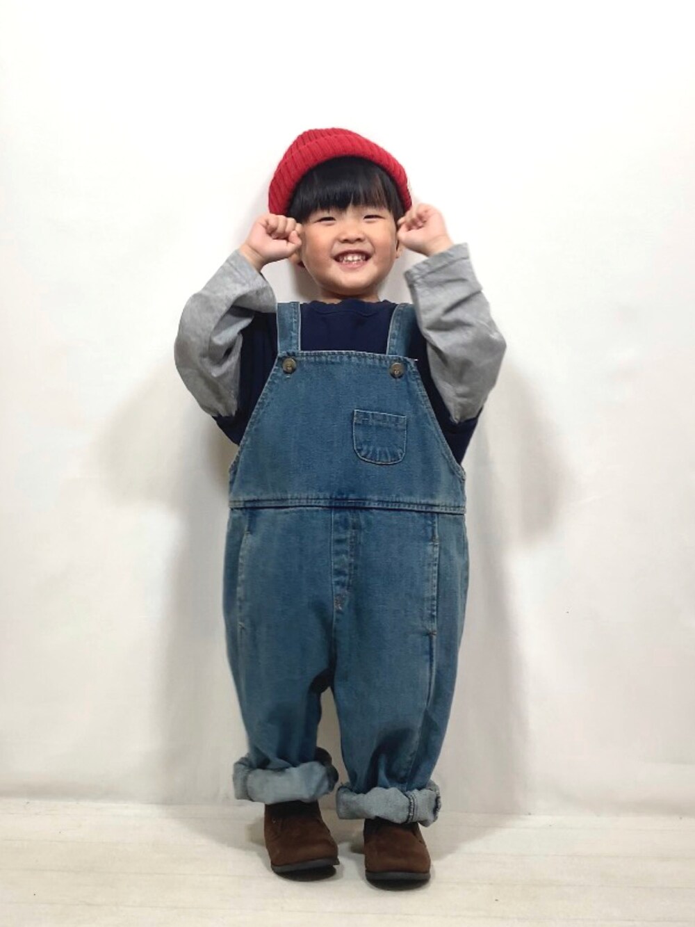 ブルー系のトップス、ブルー系のオールインワン・サロペット、ブラウン系のブーツを着用したキッズの秋コーディネートの4枚目の写真