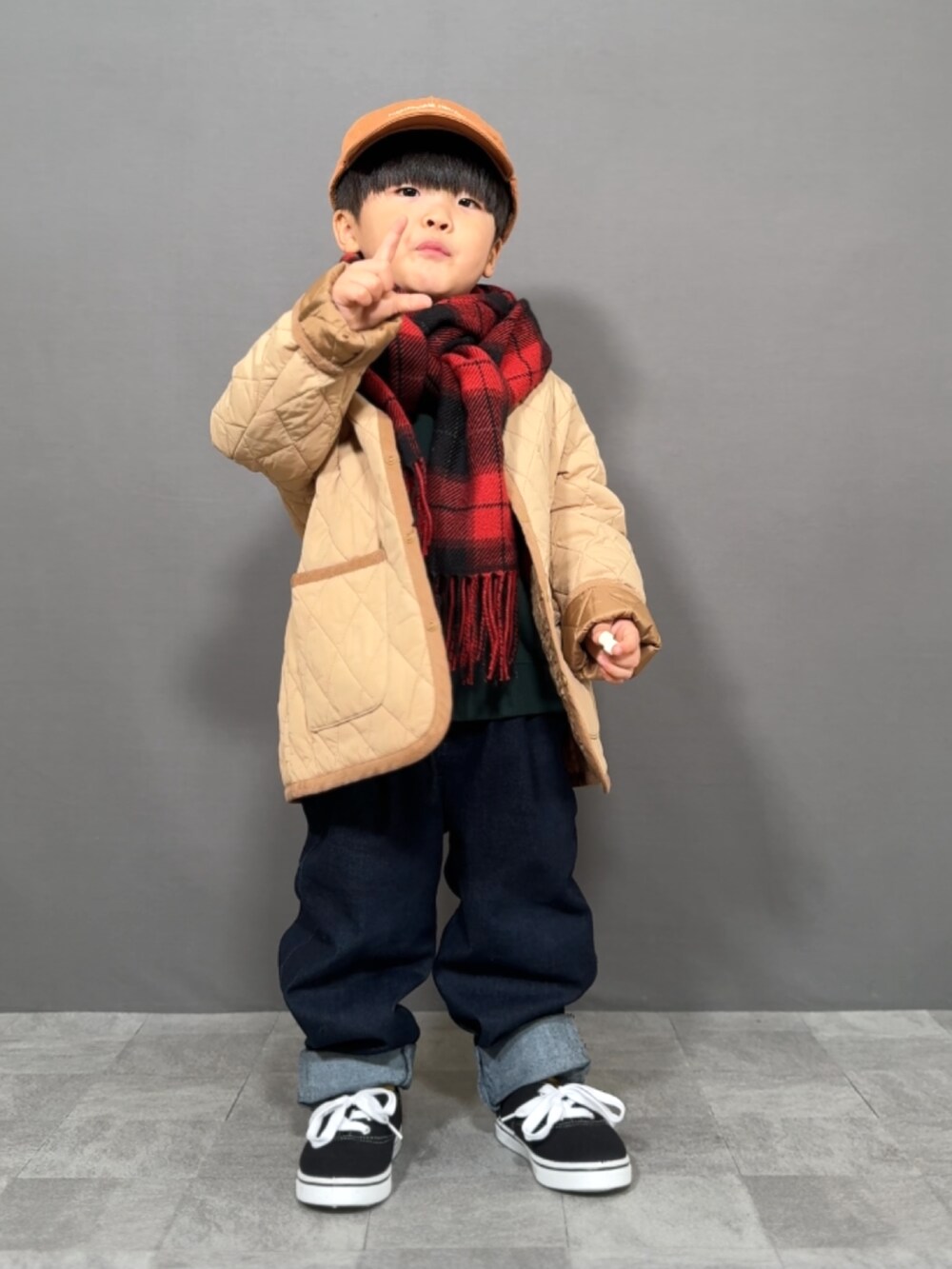 ベージュ系のジャケット/アウター、グリーン系のスウェット、ブルー系のデニムパンツを着用したキッズの冬コーディネートの3枚目の写真