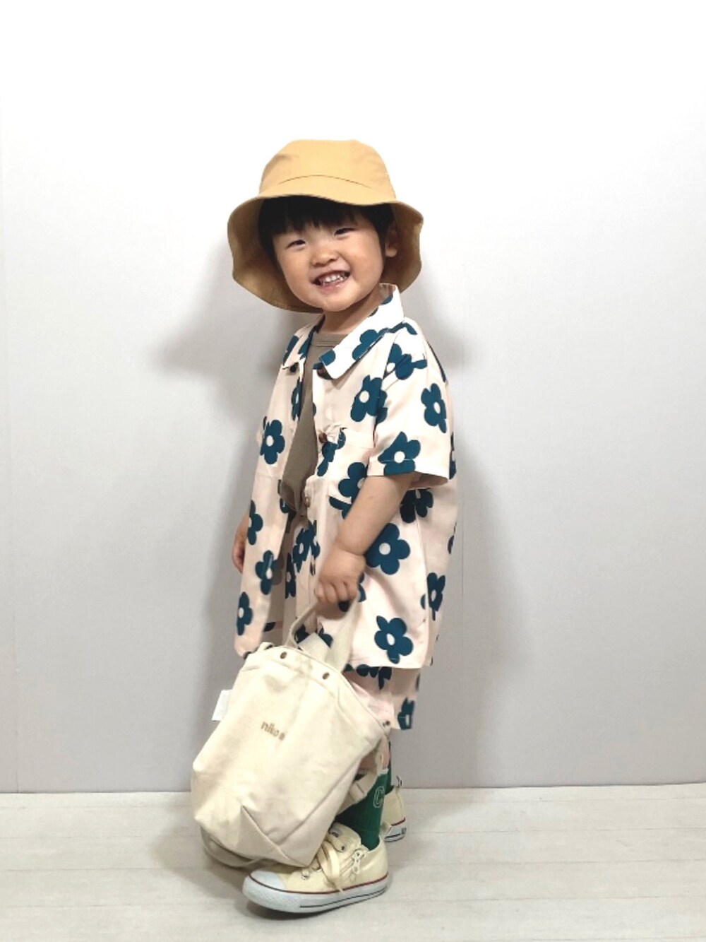 ベージュ系のセットアップ、グリーン系のTシャツ/カットソー、ホワイト系のスニーカーを着用したキッズの春コーディネートの2枚目の写真