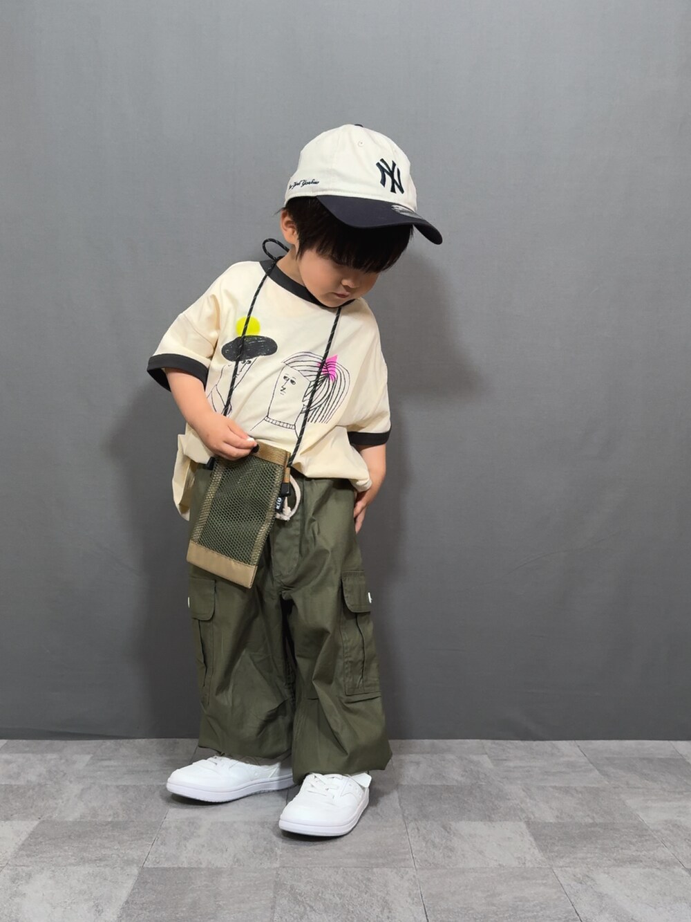 ホワイト系のTシャツ/カットソー、グリーン系のカーゴパンツ、ベージュ系のショルダーバッグを着用したキッズの夏コーディネートの3枚目の写真