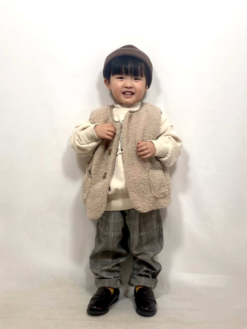 ベージュ系のベスト、ベージュ系のスウェット、ホワイト系のTシャツ/カットソーを着用したキッズの秋コーディネートの3枚目の写真